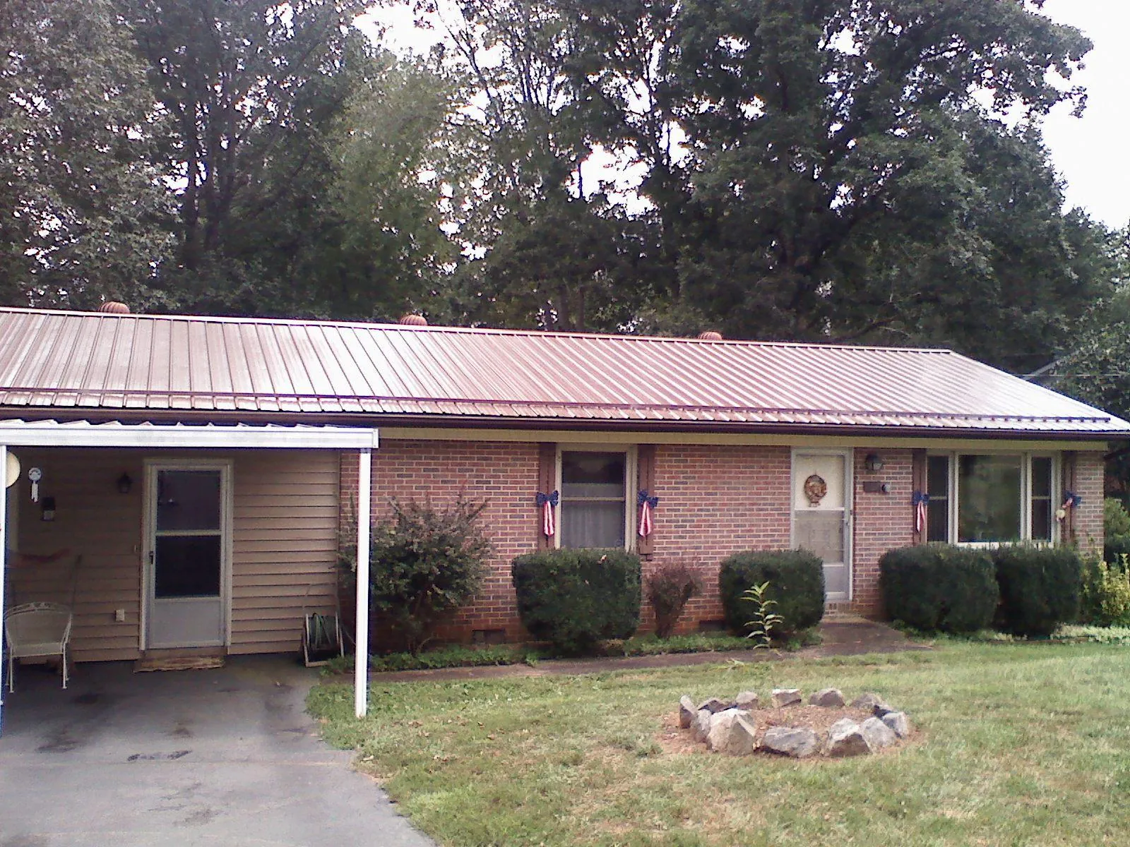 Bronze metal roof and carport on a brick ranch home — Roof Repair work by our crew in Delaware City